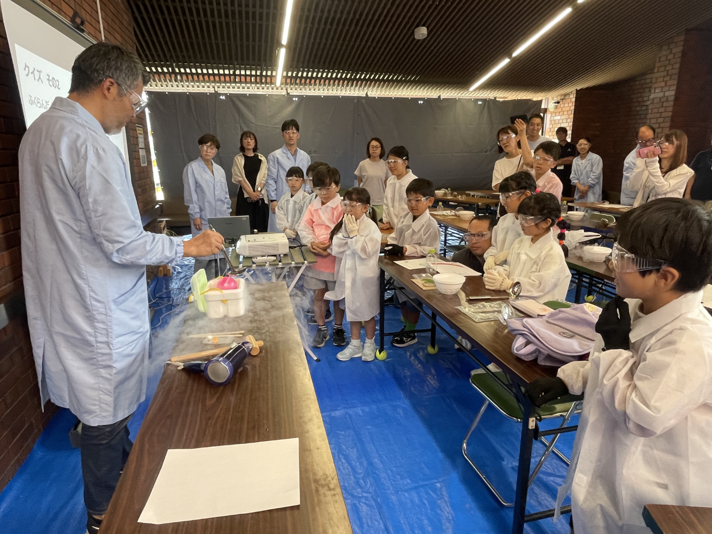 小学生に実験を教える従業員の写真